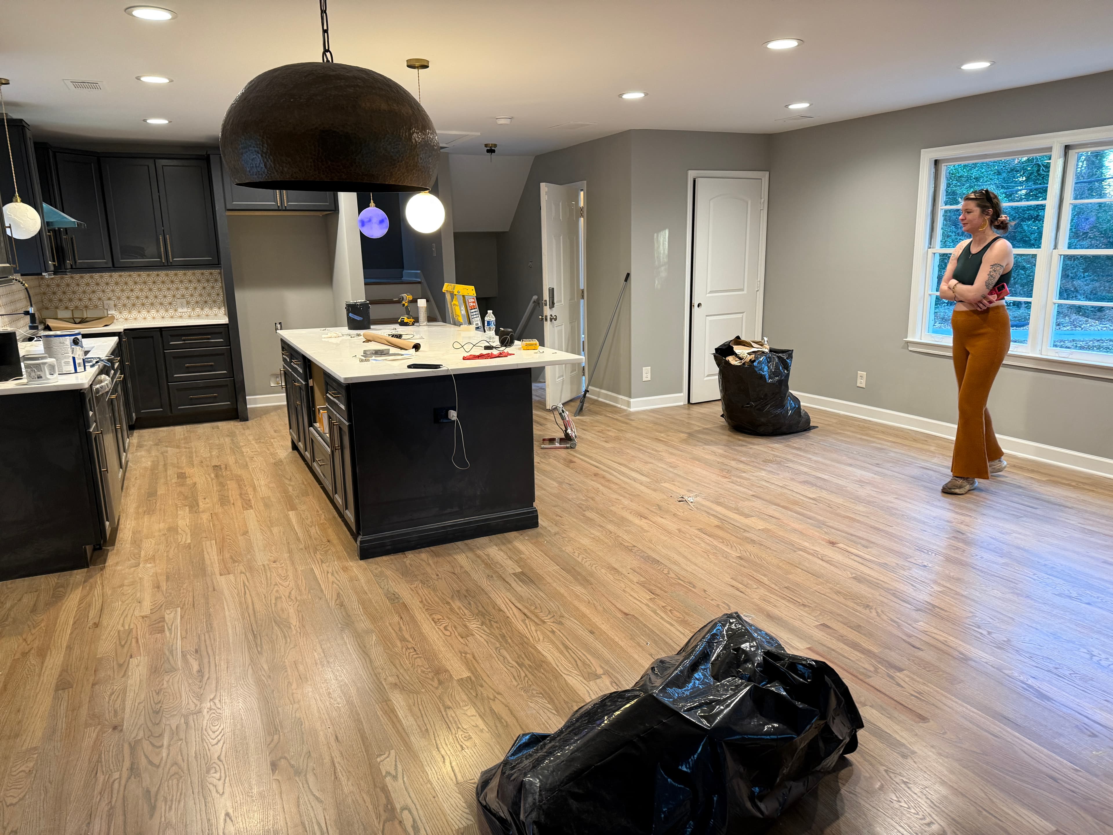 Finished open-concept kitchen and living area with new hardwood floors, completed November 2025